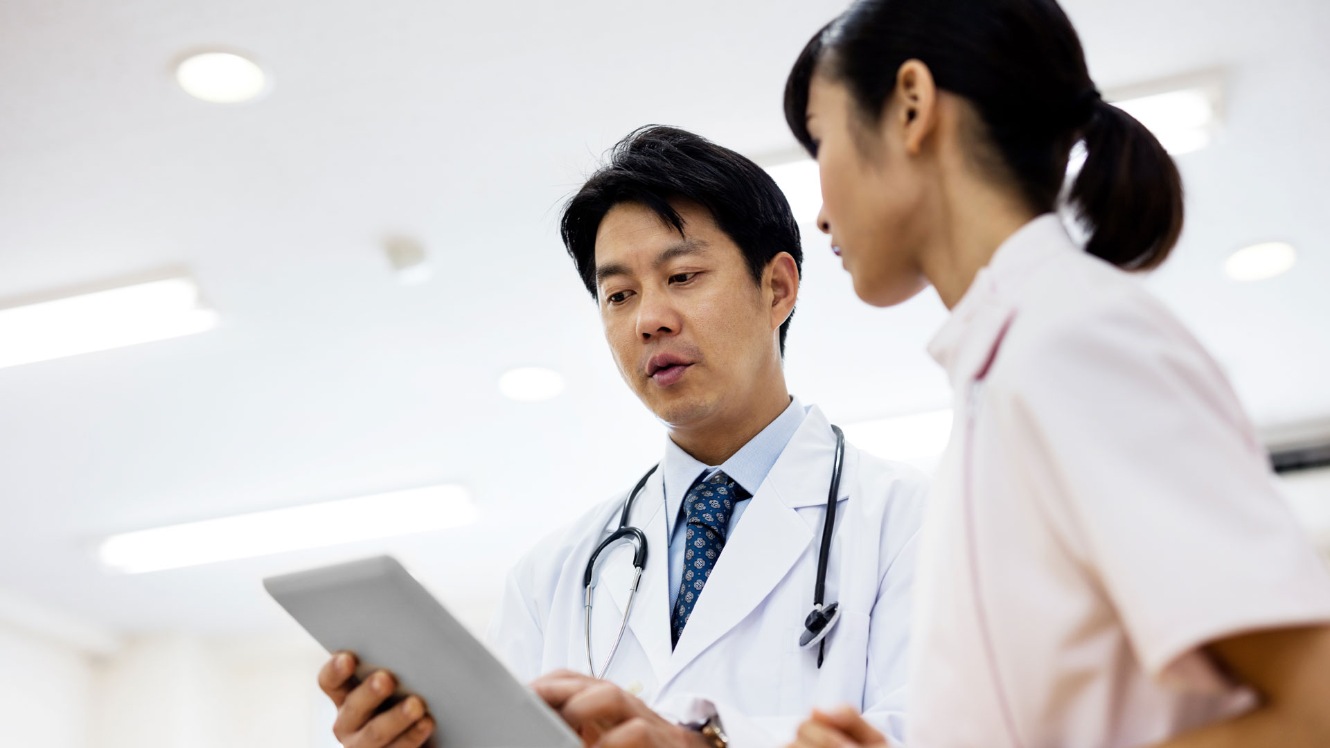 Low angle view of doctor showing digital tablet in hospital, Lung Cancer, Qualitative Research, Japan, QQFS