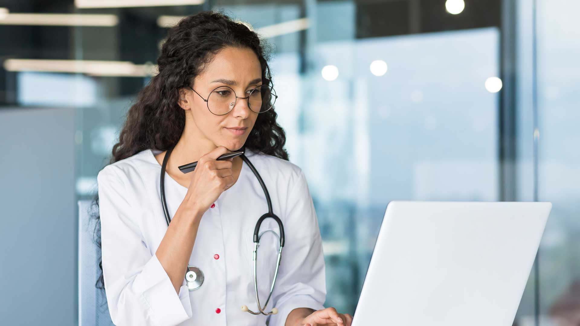 Thoughtful and serious female doctor working in office of modern clinic, wearing white medical coat, doctor using laptop for paperwork, inside building, ask the local market experts, qualitative healthcare research